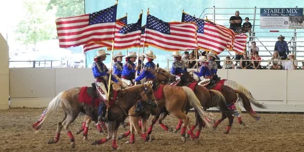 Cowgirls drill team carrying American flags