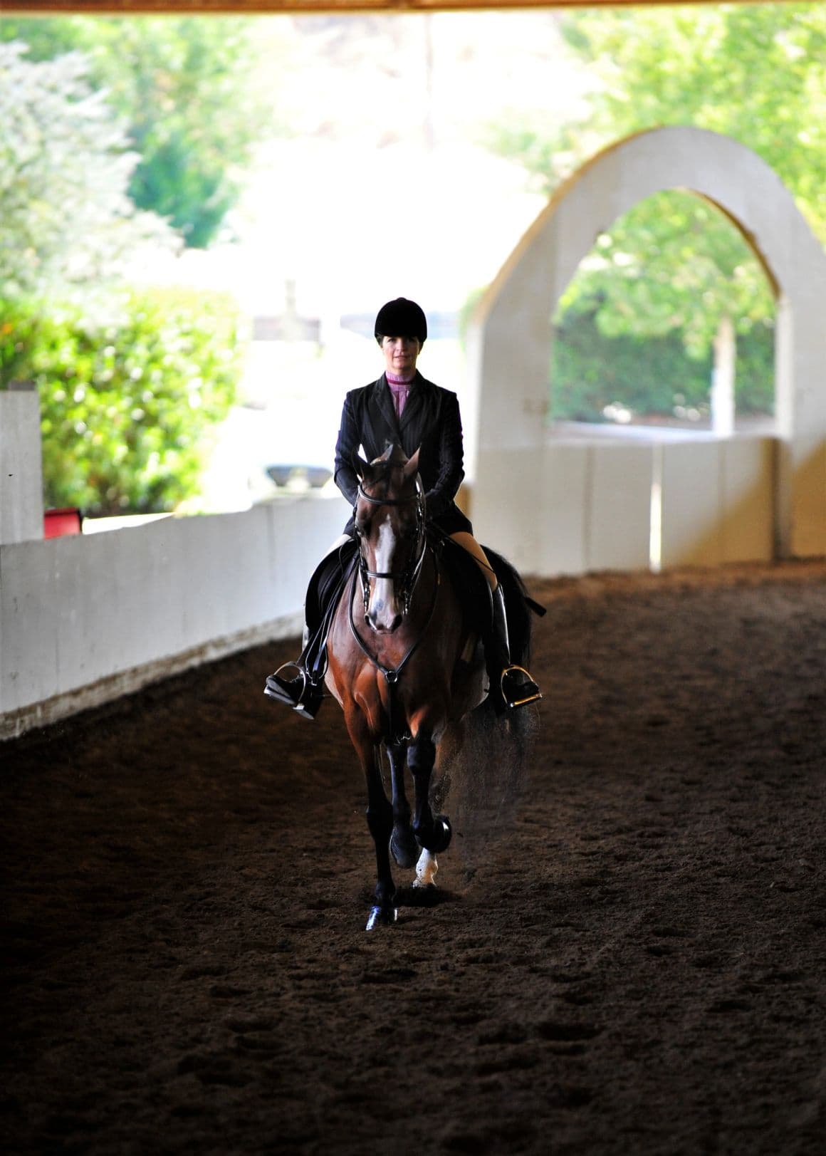 Equestrian rider entering an indoor arena